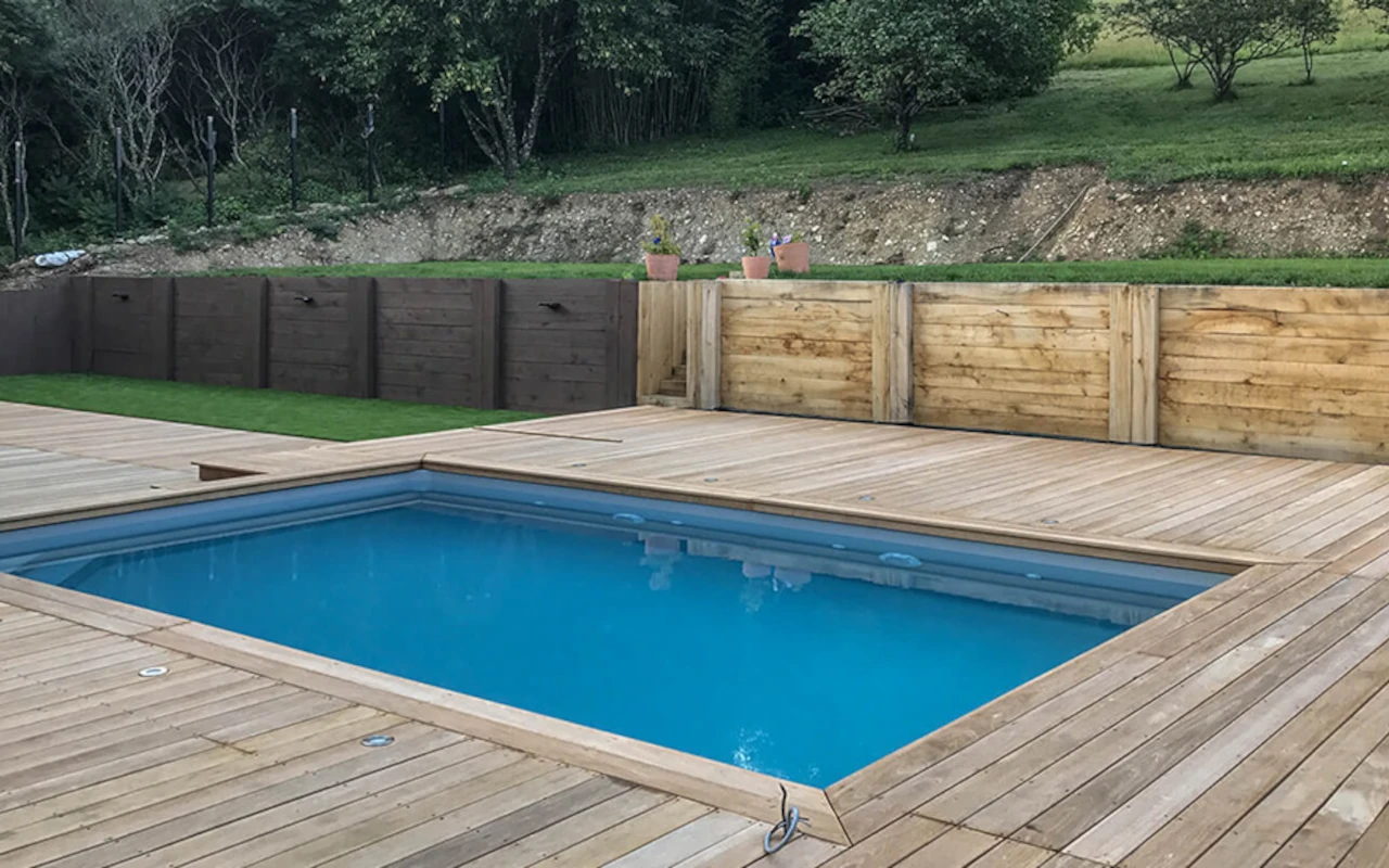 Piscine intégrée dans un aménagement paysager avec terrasse en bois