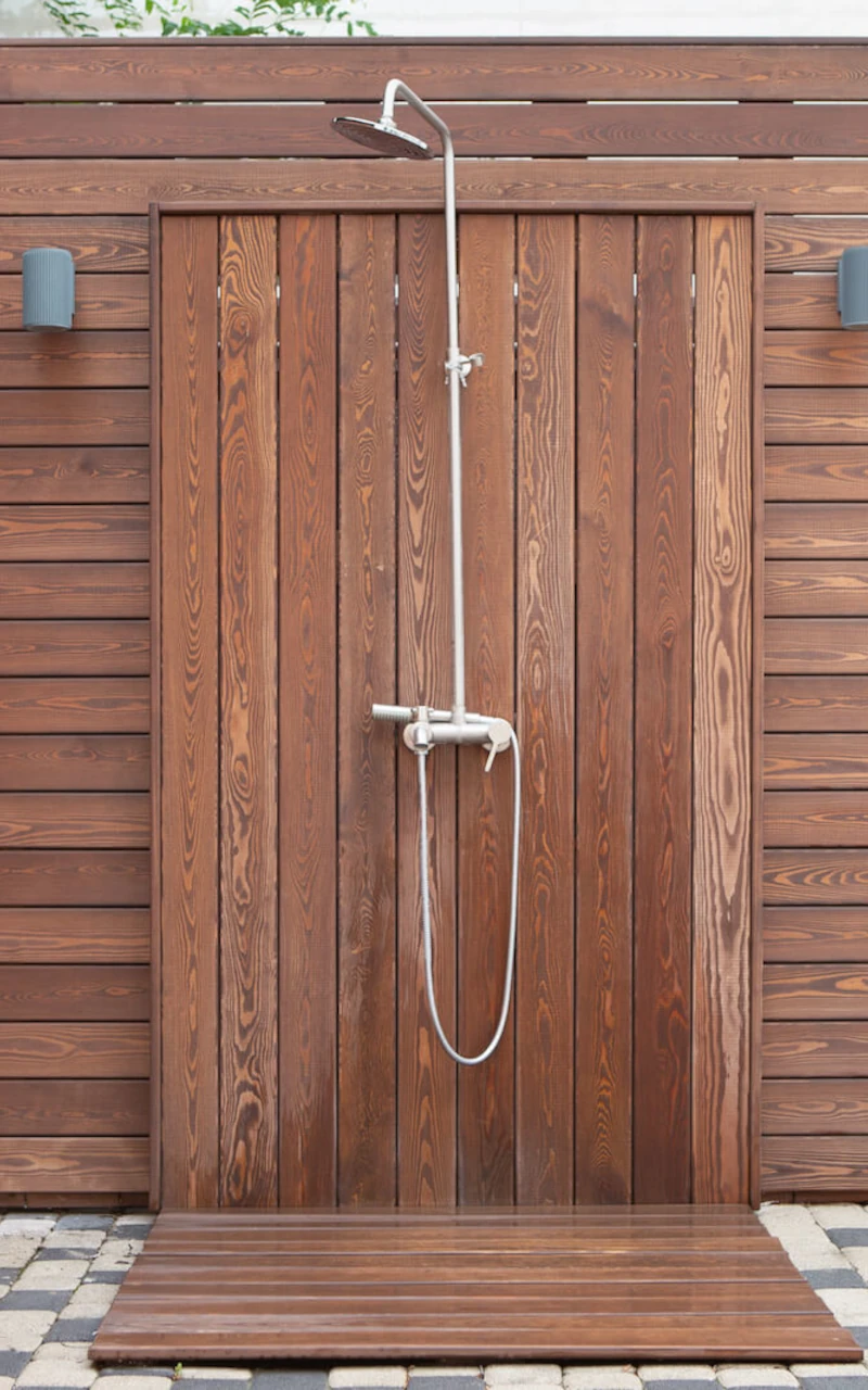 Outdoor shower installed next to a swimming pool