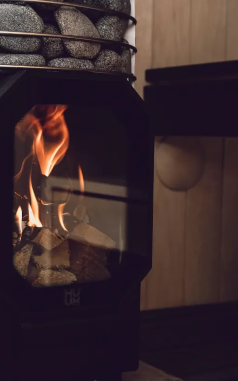 Sauna stove with heated stones and visible flame